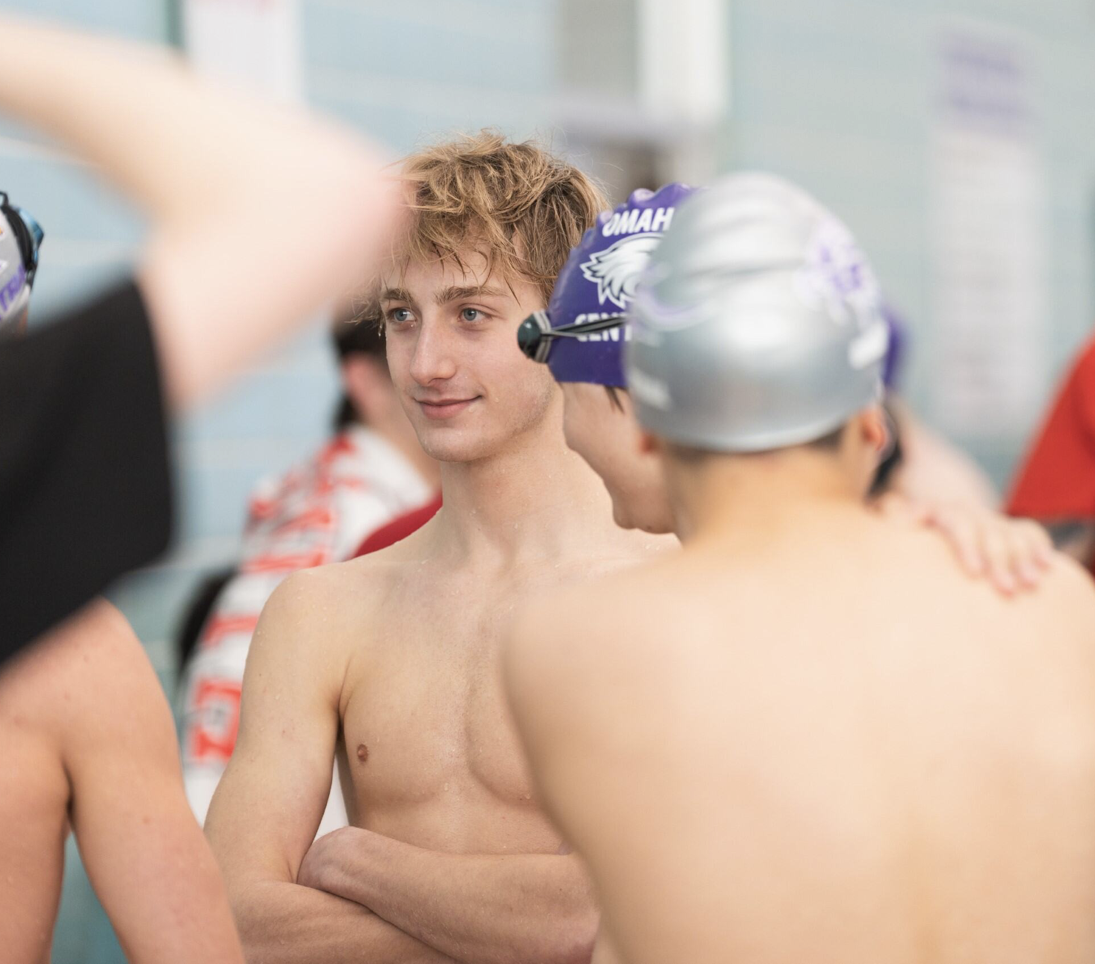 Junior Carter Hiley smiling while talking to teammates during swim meet at Norris middle school